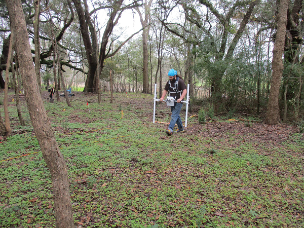 Student operating magnetometry equipment in the field.